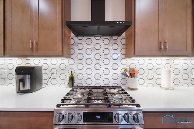 1635 Winterwood Ct, Bowling Green, OH 43402 - kitchen featuring wall chimney range hood, gas stove, light countertops, decorative backsplash, and brown cabinetry