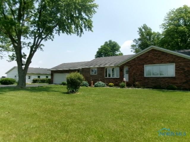 12655 Rd 11, Ottawa, OH 45875 - ranch-style home featuring an attached garage and a front lawn