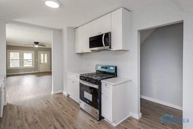 1302 Laning Rd, Toledo, OH 43615 - kitchen with appliances with stainless steel finishes, wood finished floors, light countertops, white cabinetry, and ceiling fan