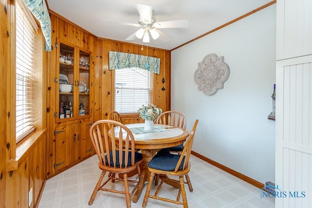 160 Wilkshire Dr, Waterville, OH 43566 - dining space featuring light floors, a ceiling fan, crown molding, and wood walls
