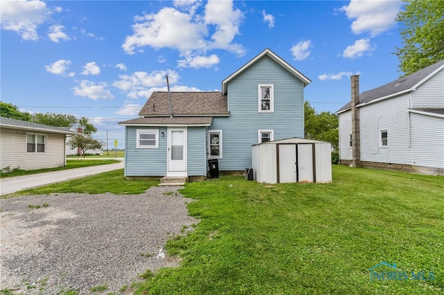 22856 Main St, Custar, OH 43511 - back of property with a lawn, a storage shed, a shingled roof, entry steps, and gravel driveway