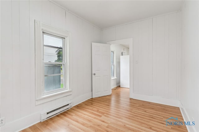 22856 Main St, Custar, OH 43511 - empty room with a baseboard radiator, light wood-style floors, crown molding, and a decorative wall