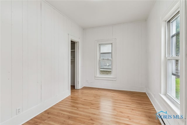 22856 Main St, Custar, OH 43511 - unfurnished bedroom featuring multiple windows, light wood-style floors, and baseboard heating