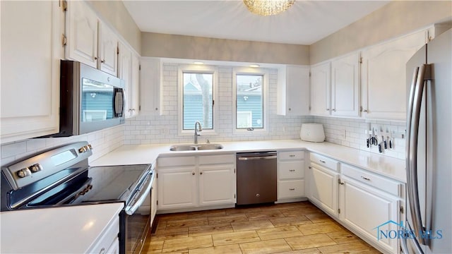 2109 Ottawa River Rd Unit 3C, Toledo, OH 43611 - kitchen with appliances with stainless steel finishes, white cabinets, backsplash, and light wood-type flooring