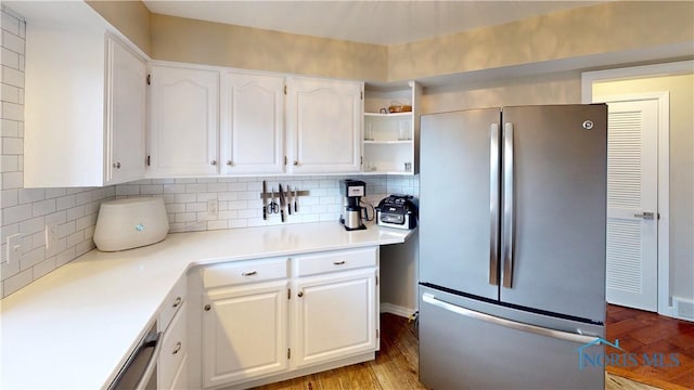 2109 Ottawa River Rd Unit 3C, Toledo, OH 43611 - kitchen featuring freestanding refrigerator, white cabinets, wood finished floors, and decorative backsplash