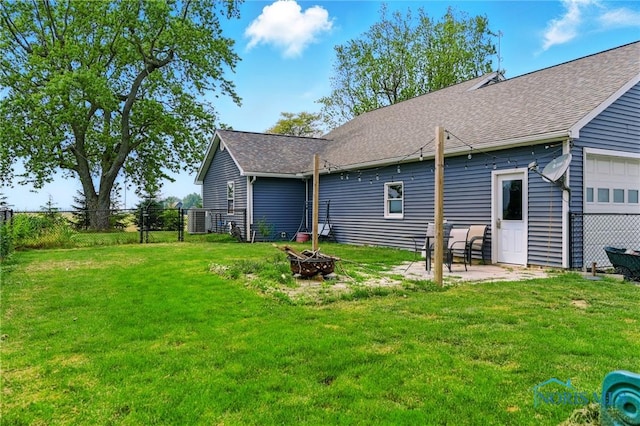 12505 Bloomlock Rd, Delphos, OH 45833 - rear view of house with an outdoor fire pit, an attached garage, and roof with shingles