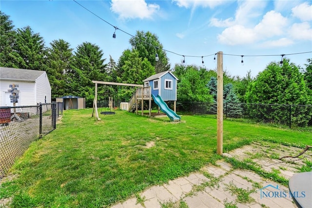 12505 Bloomlock Rd, Delphos, OH 45833 - fenced backyard featuring a playground, a storage shed, and view of scattered trees