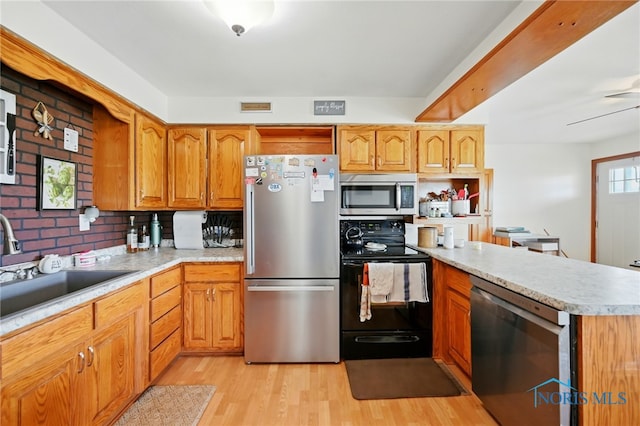 12505 Bloomlock Rd, Delphos, OH 45833 - kitchen with stainless steel appliances, a peninsula, light wood-style floors, light countertops, and brown cabinetry