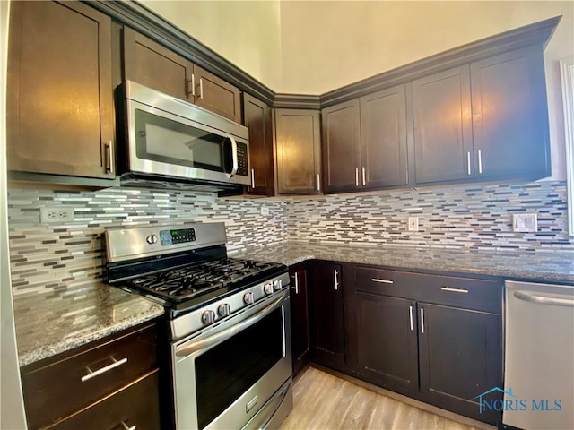 3800 Harrowsfield Rd, Sylvania, OH 43560 - kitchen with appliances with stainless steel finishes, dark stone countertops, dark brown cabinetry, and backsplash