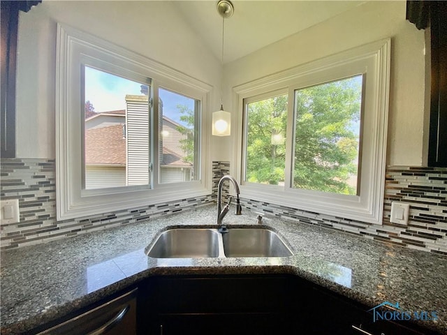 3800 Harrowsfield Rd, Sylvania, OH 43560 - kitchen featuring vaulted ceiling, decorative backsplash, dishwashing machine, dark stone countertops, and pendant lighting