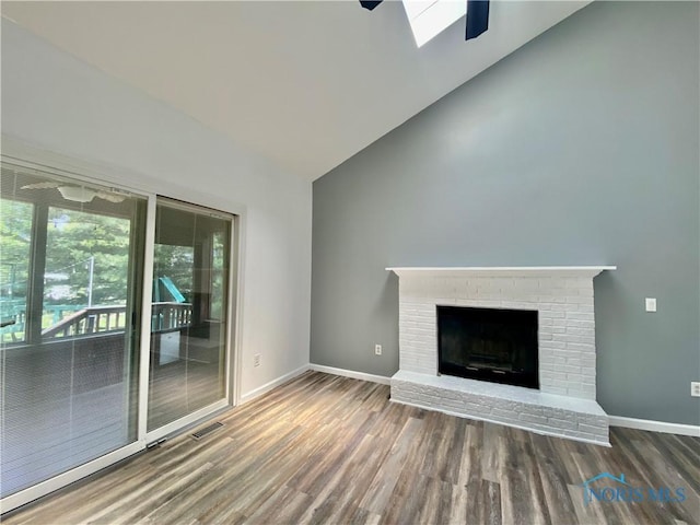 3800 Harrowsfield Rd, Sylvania, OH 43560 - unfurnished living room with high vaulted ceiling, wood finished floors, a brick fireplace, and a skylight