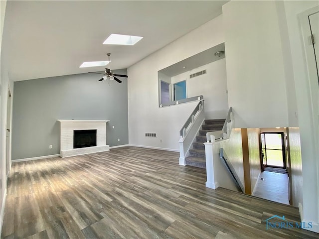 3800 Harrowsfield Rd, Sylvania, OH 43560 - unfurnished living room with a skylight, wood finished floors, high vaulted ceiling, a fireplace, and ceiling fan