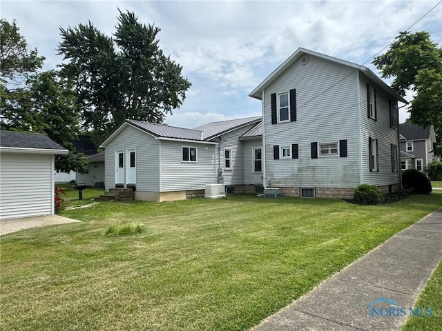 201 E Rings St, West Unity, OH 43570 - back of property featuring entry steps, a lawn, and a metal roof