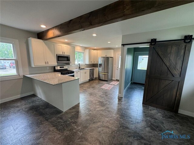 201 E Rings St, West Unity, OH 43570 - kitchen with stainless steel appliances, light countertops, white cabinets, a peninsula, and recessed lighting