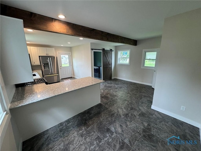 201 E Rings St, West Unity, OH 43570 - kitchen featuring stainless steel refrigerator with ice dispenser, a barn door, white cabinets, healthy amount of natural light, and recessed lighting