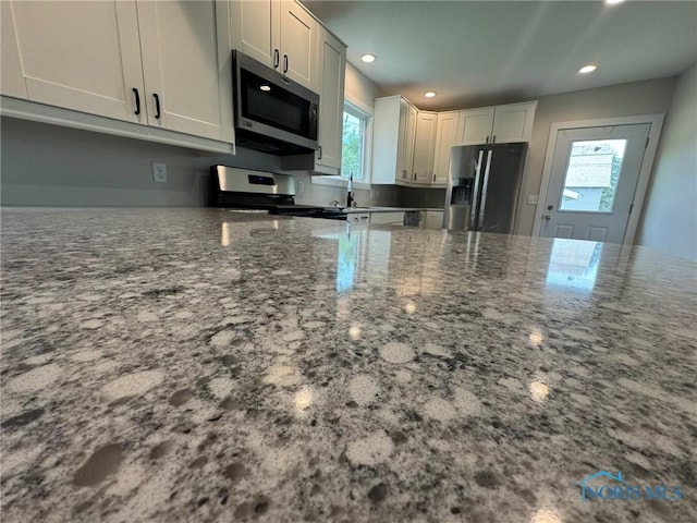 201 E Rings St, West Unity, OH 43570 - kitchen featuring appliances with stainless steel finishes, dark stone countertops, recessed lighting, and white cabinetry