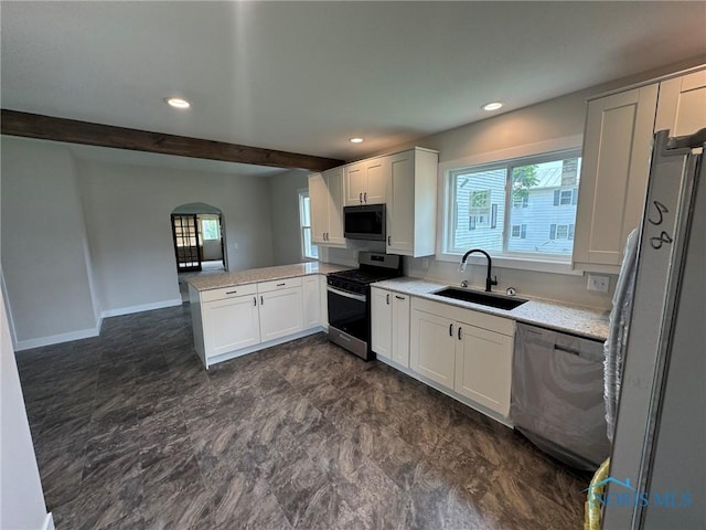 201 E Rings St, West Unity, OH 43570 - kitchen with appliances with stainless steel finishes, a peninsula, white cabinets, light countertops, and healthy amount of natural light