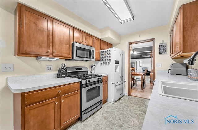 238 Richards Rd, Toledo, OH 43607 - kitchen featuring stainless steel appliances, light countertops, and brown cabinets
