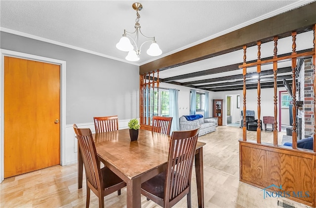 238 Richards Rd, Toledo, OH 43607 - dining room with a chandelier, crown molding, a textured ceiling, and light wood-style flooring