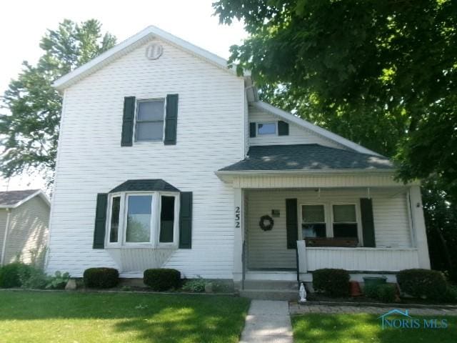 252 N Walnut St, Ottawa, OH 45875 - view of front facade featuring covered porch and a front lawn
