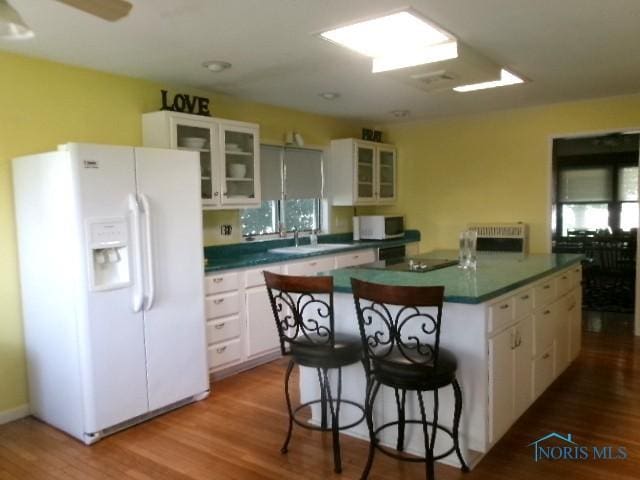 252 N Walnut St, Ottawa, OH 45875 - kitchen with white appliances, dark countertops, white cabinetry, and wood finished floors