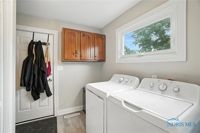 1022 Clough St, Bowling Green, OH 43402 - washroom featuring separate washer and dryer, cabinet space, and light wood-type flooring