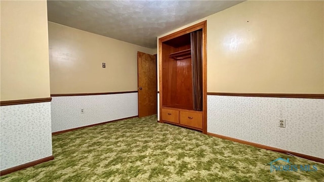 825 Johnson Rd, Paulding, OH 45879 - spare room with carpet, wallpapered walls, a textured ceiling, and wainscoting