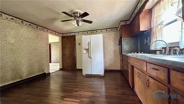 825 Johnson Rd, Paulding, OH 45879 - kitchen with white fridge with ice dispenser, dark wood finished floors, wallpapered walls, ceiling fan, and brown cabinets