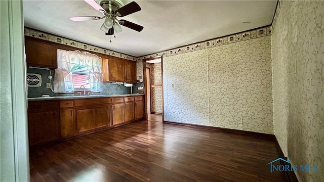 825 Johnson Rd, Paulding, OH 45879 - kitchen with dark wood finished floors, ceiling fan, brown cabinets, and wallpapered walls