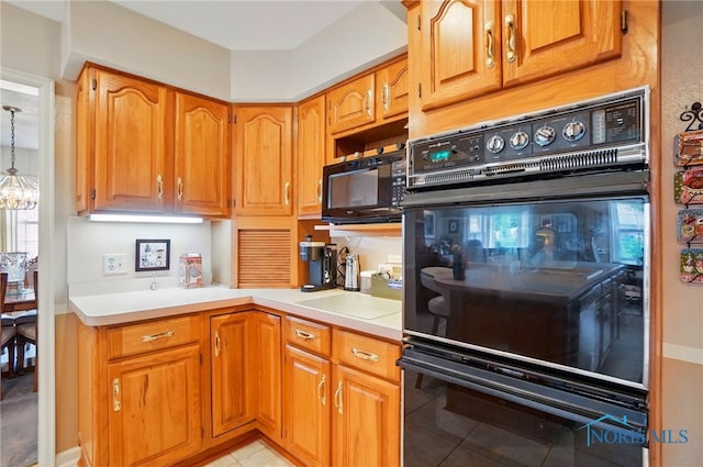 1309 Gettysburg Dr, Maumee, OH 43537 - kitchen featuring black appliances, light countertops, light tile patterned floors, brown cabinetry, and decorative light fixtures