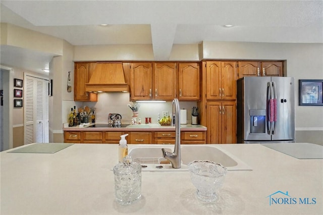 1309 Gettysburg Dr, Maumee, OH 43537 - kitchen with stainless steel fridge with ice dispenser, custom range hood, brown cabinets, light countertops, and recessed lighting