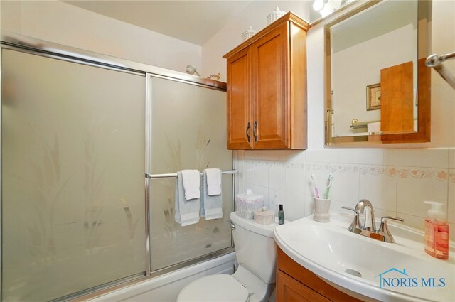 1309 Gettysburg Dr, Maumee, OH 43537 - bathroom featuring vanity, shower / bath combination with glass door, and tasteful backsplash