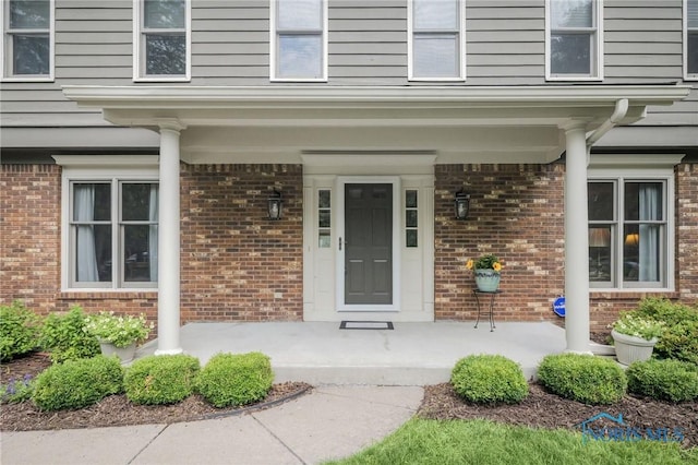 7040 Country Creek Rd, Maumee, OH 43537 - doorway to property featuring covered porch and brick siding