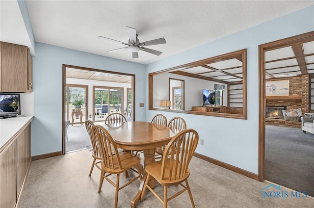 7040 Country Creek Rd, Maumee, OH 43537 - dining room with ceiling fan, a brick fireplace, light colored carpet, and beamed ceiling