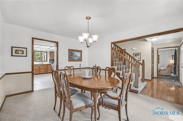 7040 Country Creek Rd, Maumee, OH 43537 - dining room featuring a chandelier, stairway, and light carpet