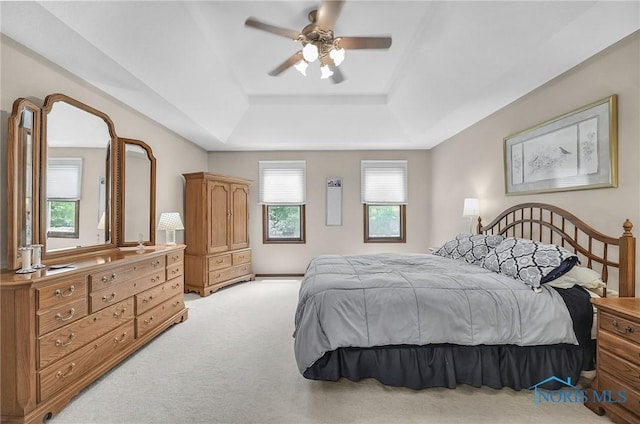 7040 Country Creek Rd, Maumee, OH 43537 - bedroom featuring a tray ceiling, light colored carpet, and a ceiling fan