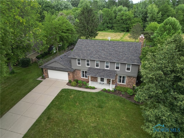 7040 Country Creek Rd, Maumee, OH 43537 - view of front facade with brick siding, driveway, a front yard, and a garage
