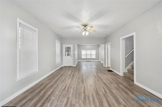 2336 Caledonia St, Toledo, OH 43605 - unfurnished living room featuring wood finished floors, stairs, and ceiling fan