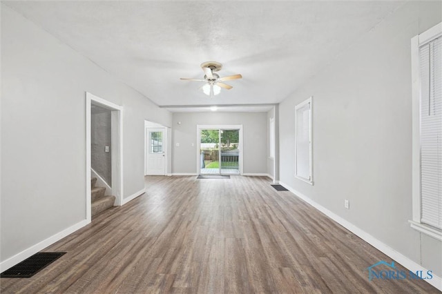 2336 Caledonia St, Toledo, OH 43605 - unfurnished living room with wood finished floors, ceiling fan, and stairway