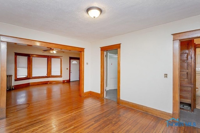 433 Islington St, Toledo, OH 43610 - unfurnished room featuring radiator, hardwood / wood-style floors, a ceiling fan, and a textured ceiling