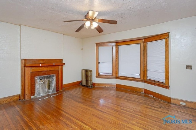 433 Islington St, Toledo, OH 43610 - unfurnished living room featuring radiator, hardwood / wood-style flooring, a ceiling fan, and a textured ceiling