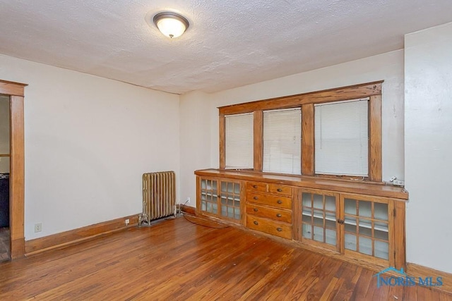 433 Islington St, Toledo, OH 43610 - empty room with radiator, wood finished floors, and a textured ceiling