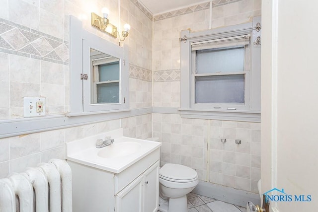 433 Islington St, Toledo, OH 43610 - bathroom with tile walls, radiator heating unit, vanity, and tile patterned flooring