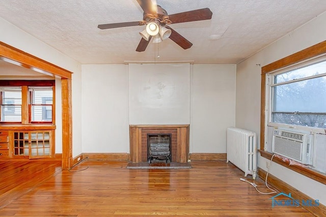 433 Islington St, Toledo, OH 43610 - unfurnished living room with radiator, a textured ceiling, wood finished floors, ceiling fan, and cooling unit