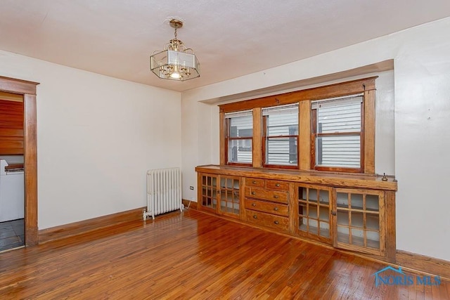 433 Islington St, Toledo, OH 43610 - spare room featuring radiator heating unit, hardwood / wood-style flooring, and a chandelier