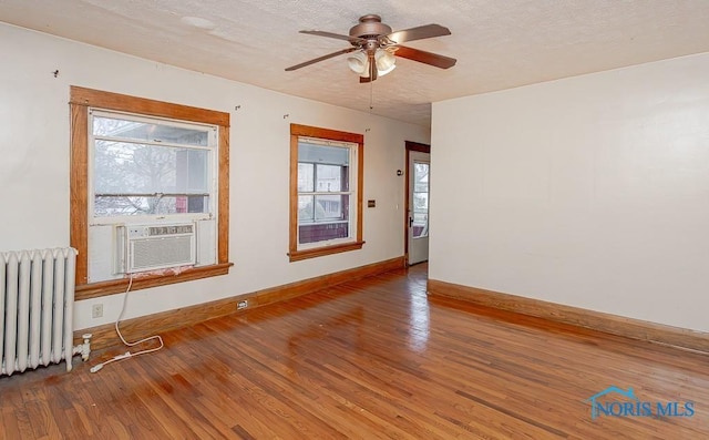 433 Islington St, Toledo, OH 43610 - spare room with radiator heating unit, wood finished floors, ceiling fan, cooling unit, and a textured ceiling