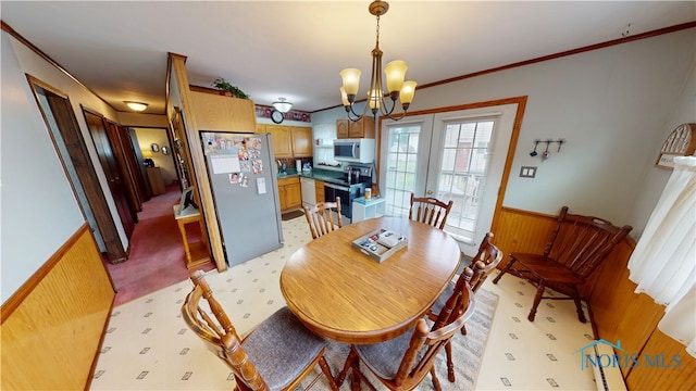 43 Longfellow Dr, Tiffin, OH 44883 - dining area with a wainscoted wall, wood walls, a chandelier, and ornamental molding