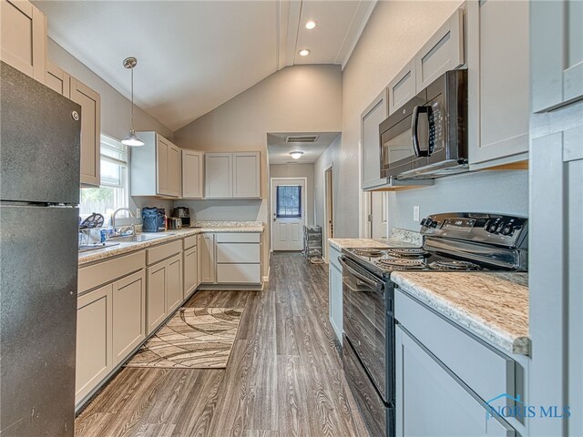 5161 Langham Dr, Sylvania, OH 43560 - kitchen with black appliances, light wood finished floors, light countertops, pendant lighting, and high vaulted ceiling