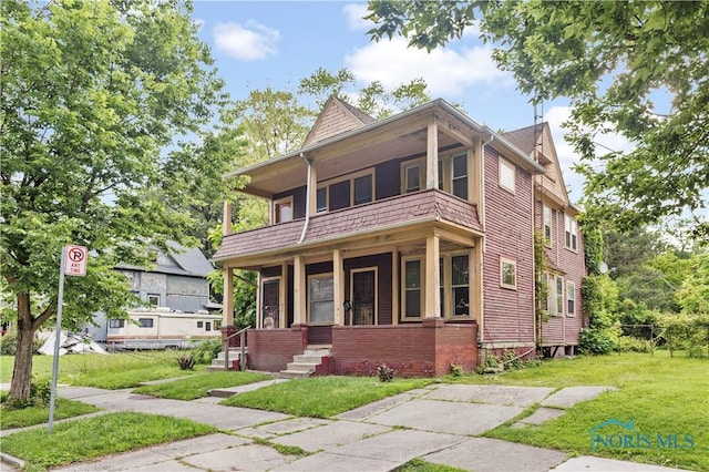 2360 Maplewood Ave, Toledo, OH 43620 - victorian-style house featuring a balcony and a front yard