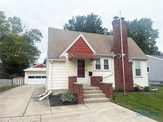 1007 Leonard Ct, Fostoria, OH 44830 - bungalow-style house featuring an outbuilding, a garage, roof with shingles, and a chimney